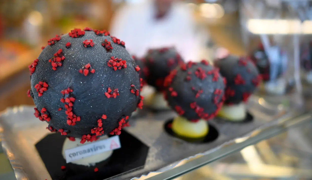Pembuat cokelat, Jean-François Pre menunjukkan telur paskah berbentuk seperti Virus Corona di tokonya di Landivisiau, Prancis, 7 Maret 2020. Cokelat ini terbuat dari cokelat putih yang diberikan pewarna hitam serta dipadukan dengan kacang almond yang diwarnai merah. (Damien MEYER/AFP)