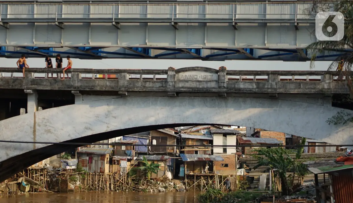 Anak-anak bermain di jembatan Sungai Ciliwung, Jakarta, Senin (5/10/2020). Pemprov DKI mencatat kenaikan angka kemiskinan Jakarta sebesar 1,11 persen menjadi 4,53 persen pada bulan September 2020 karena terdampak pandemi COVID-19. (Liputan6.com/Immanuel Antonius)