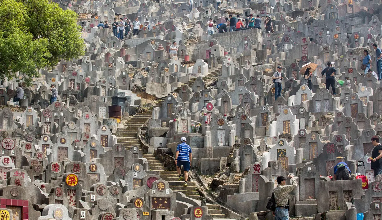 Warga mengunjungi makam keluarga dan kerabat selama festival Qingming di pemakaman di Hong Kong (5/4). Festival Qingming atau dikenal sebagai Hari Pembersihan Makam untuk menghormati orang yang dicintainya yang telah tiada. (AFP Photo/Isaac Lawrence)