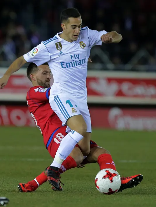 Aksi pemain Real Madrid, Lucas Vazquez (kanan) melewati adangan pemain Numancia, Grego pada laga Copa Del Rey di Nuevo Estadio Los Pajaritos stadium, Soria, (4/1/2018). Madrid menang 3-0. (AFP/Cesar Manso)