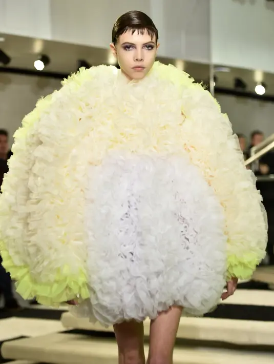 Seorang model berjalan di runway mengenakan koleksi busana rancangan desainer Jepang, Tomo Koizumi  pada New York Fashion Week di Marc Jacobs Madison, 8 Februari 2019. Koizumi menampilkan parade gaun awan berwarna pelangi (Steven Ferdman/Getty Images/AFP)