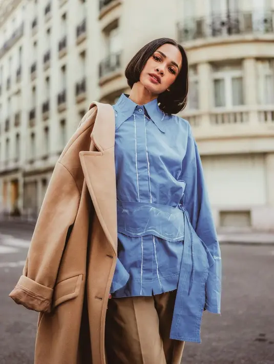 Ia memadukan kemeja biru dengan coat dan celana cokelat yang terlihat trendy [instagram/andienaisyah]