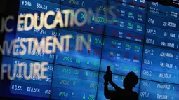 Pengunjung melintas di dekat monitor perkembangan saham di Bursa Efek Indonesia, Jakarta, Senin (2/11).  Indeks Harga Saham Gabungan (IHSG) di Bursa Efek Indonesia (BEI) pada Senin dibuka melemah sebesar 12,76 poin. (Liputan6.com/Immanuel Antonius)