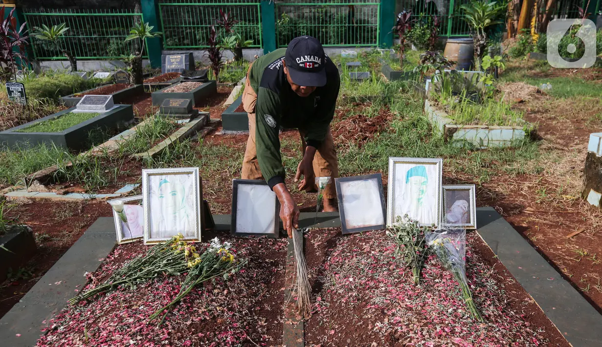 Sardi, pengurus makam membersihkan makam Vanessa Angel dan Bibi Ardiansyah di TPU Taman Makam Islam Malaka Blok D, Pesanggrahan, Jakarta, Senin (7/02/2022). Makam yang berada di atas tanah wakaf dirapikan dengan semen oleh pengurus makam agar tanah tidak amblas. (Liputan6.com/Fery Pradolo)
