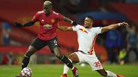 Pemain Manchester United Paul Pogba (kiri) berebut bola dengan pemain RB Leipzig Benjamin Henrichs pada pertandingan Grup H Liga Champions di Stadion Old Trafford, Manchester, Inggris, Rabu (28/10/2020. Manchester United menang 5-0, Marcus Rashford cetak hattrick. (AP Photo/Dave Thompson)