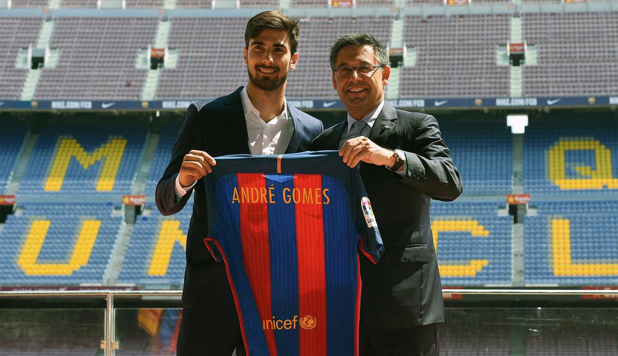 Pemain baru Barcelona, Andre Gomes (kiri) berfoto di samping Presiden Barcelona, Josep Maria Bartomeu saat diperkenalkan secara resmi di Camp Nou Stadium, Barcelona (27/7/2016). Andre Gomes didatangkan Barcelona dari Valencia pada awal musim 2016/2017 dengan nilai transfer sebesar 37 juta euro atau kini setara Rp595 miliar. Bertahan selama dua musim, ia total tampil dalam 78 laga di semua ajang dengan torehan 3 gol dan 4 assist. (AFP/Lluis Gene)