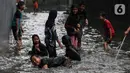 Anak-anak bermain air saat banjir merendam lingkungan rumah tempat tinggal mereka di kawasan kecamatan Kebayoran Baru, Jakarta, Senin (25/01/2021). Hujan deras yang mengguyur Jakarta hari ini, Senin (25/1) menyebabkan terjadinya banjir di kawasan permukiman tersebut. (Liputan6.com/Johan Tallo)