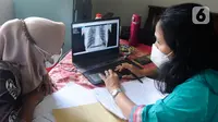 Warga melihat hasil ronsen mobile  X-Ray Artificial Intelligence saat kegiatan skrining penyakit tuberkulosis (TBC) di Kantor Kecamatan Cipayung, Depok, Jawa Barat, Rabu (4/1/2023). Penyakit tuberkulosis (TBC) di Indonesia menempati peringkat ketiga setelah India dan Cina dengan jumlah kasus 824 ribu dan kematian 93 ribu per tahun atau setara dengan 11 kematian per jam. (merdeka.com/Arie Basuki)