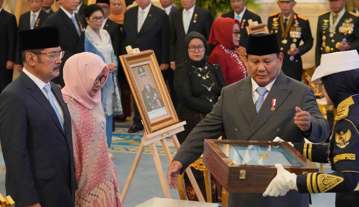 Penganugerahan itu diberikan langsung kepada ahli warisnya yang hadir di Istana, yakni Bambang Trihatmodjo dan Siti Hardijanti Rukmana. Tampak dalam foto, Presiden Indonesia Prabowo Subianto (kedua dari kanan) menyerahkan sertifikat gelar pahlawan nasional kepada putra dan putri mendiang Presiden Suharto, Siti Hardiyanti Rukmana (kedua dari kiri) dan Bambang Trihatmojo, dalam upacara pemberian gelar pahlawan nasional kepada sepuluh tokoh di Istana Negara di Jakarta, Senin 10 November 2025. (AP Photo/Achmad Ibrahim)