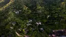 Kondisi sejumlah rumah yang ditutupi tumbuhan di Houtouwan di pulau Shengshan, provinsi Zhejiang, China (1/6). Lama tak berpenghuni, rumah dan bangunan di Houtouwan tampak tertelan hijaunya tanaman merambat. (AFP/Johannes Eisele)