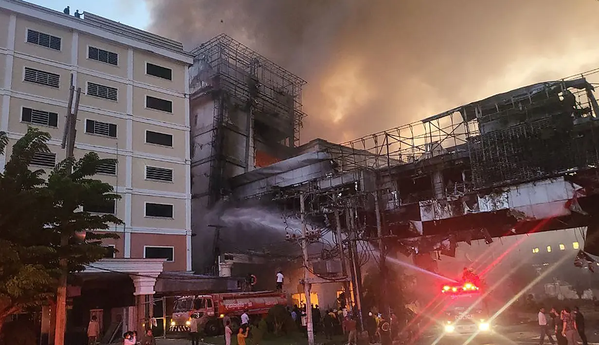 Petugas pemadam kebakaran menyemprotkan air ke lokasi kebakaran di hotel-kasino Grand Diamond City di Poipet pada 29 Desember 2022. Sebanyak 10 orang tewas dalam kebakaran di hotel-kasino Kamboja di perbatasan Thailand, dengan foto menunjukkan kelompok mati-matian meringkuk di tepian saat api yang ganas mengelilingi mereka. (AFP/STR)