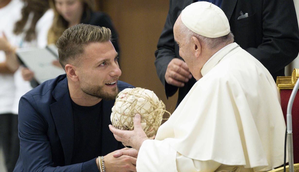 Pemain Lazio, Ciro (kiri) Immobile berbincang dengan Paus Fransiskus speaks with Pope Francis saat menghadiri audiensi dengan peserta pertandingan penghormatan "match for peace" untuk mengenang mendiang pemain Argentina, Diego Maradona, pada 14 November 2022 di aula Paul-VI, Vatikan. Pertandingan ini diselenggarakan oleh "WePlayForPeace", sebuah yayasan yang didirikan oleh Paus Fransiskus. (AFP/Vatican Media)