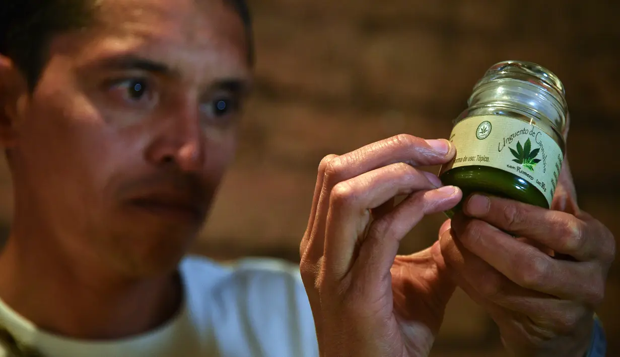 Seorang pria memegang produk medis yang terbuat dari ganja di sebuah pameran produk ganja untuk obat di Bogota, Kolombia, Selasa (22/12). Pemerintah Kolombia telah melegalkan penggunaan ganja untuk keperluan medis. (AFP PHOTO/Guillermo LEGARIA)