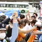 Orang-orang bereaksi setelah tembakan di Nara, Jepang barat (8/7/2022). NHK dan Kyodo sama-sama melaporkan Abe dibawa ke rumah sakit dan tampaknya mengalami cardo-respiratory arrest-istilah yang digunakan di Jepang untuk menunjukkan tidak ada tanda-tanda vital, dan umumnya mendahului sertifikasi formal kematian oleh koroner. (Kyodo News via AP)