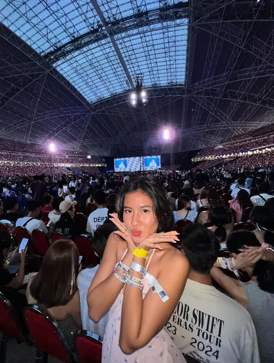 Shenina tampil manis dengan halterneck mini dress putih dan deretan gelang di tangan [@sheninacinnamon]