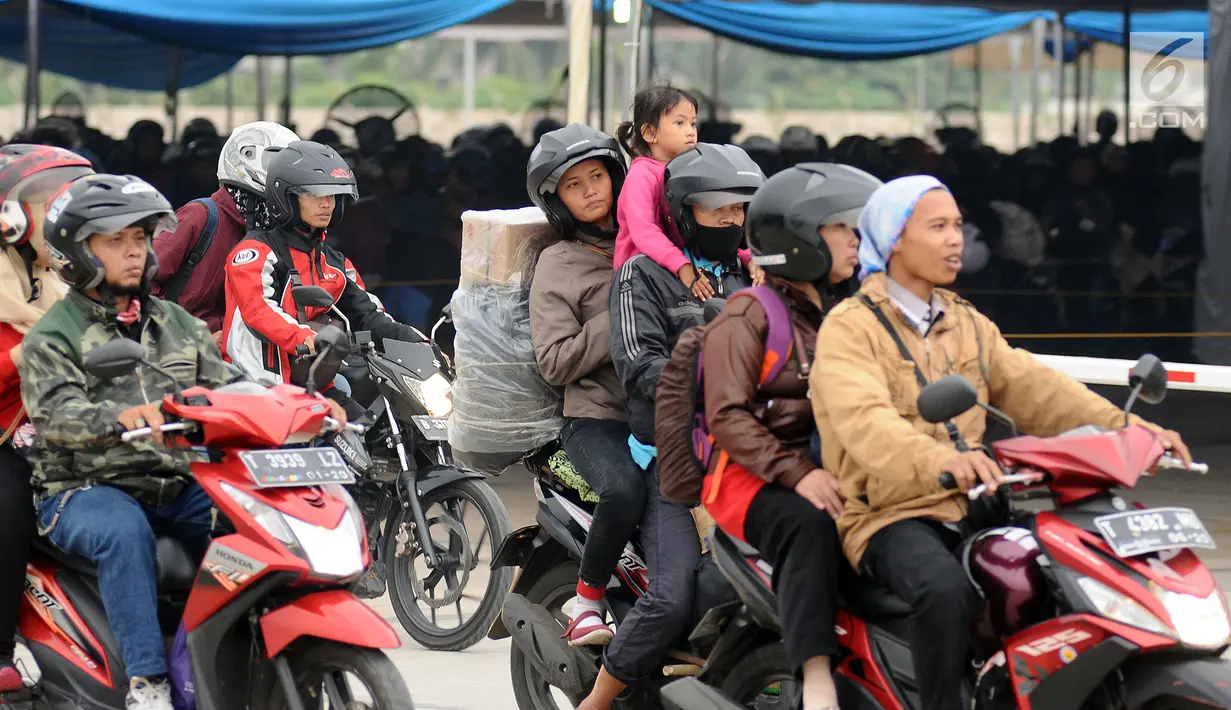 Pemudik membawa anaknya saat akan memasuki kapal penyereberangan di Dermaga 6 Pelabuhan Merak, Banten, Kamis (22/6). Meski sudah dihimbau oleh pihak berwenang, namun masih banyak pemudik bermotor yang membawa anak. (Liputan6.com/Helmi Fithriansyah)
