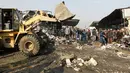 Buldoser digunakan untuk mengevakuasi puing-puing bekas ledakan bom di pasar sayur Jumila di Baghdad, Irak (8/1). Sejauh ini belum ada pihak yang mengaku bertanggung jawab atas serangan yang menghantam pasar di Baghdad itu. (AFP/Sabar Arar)