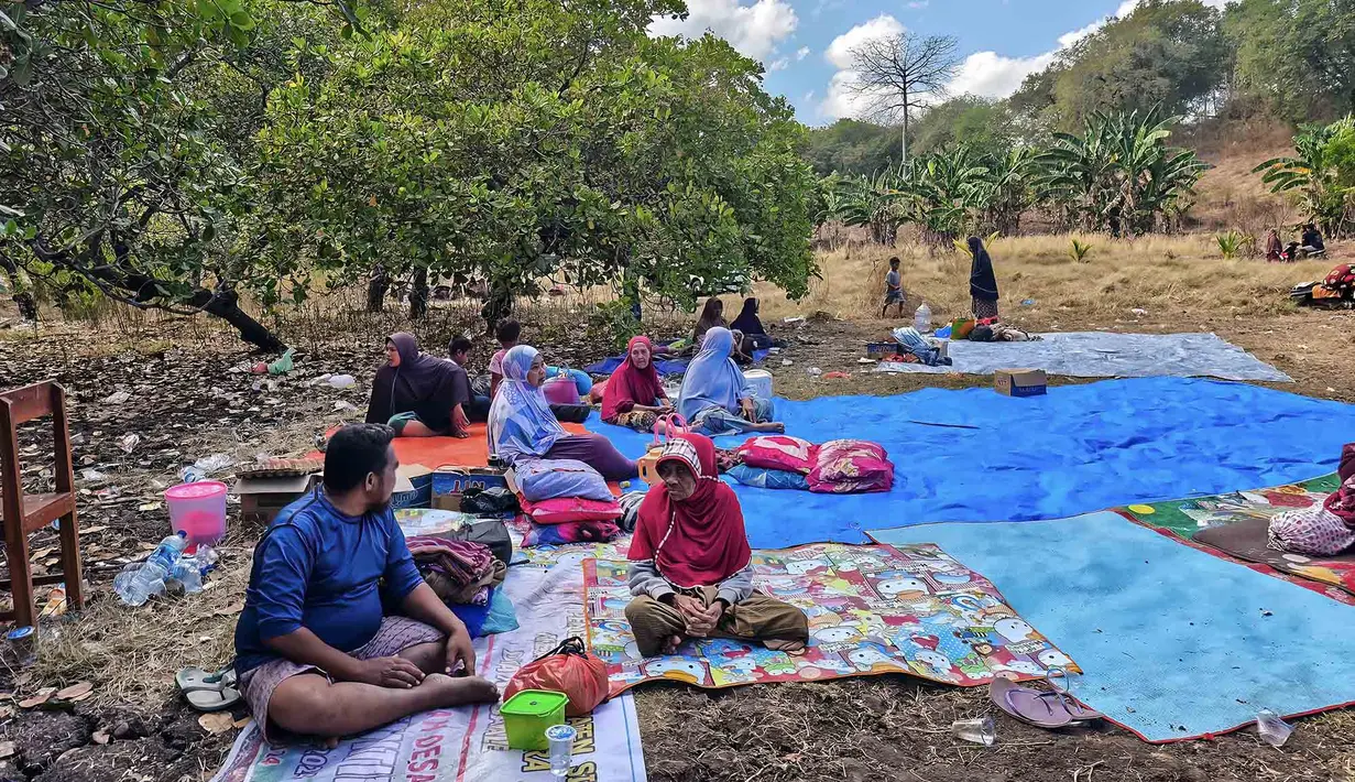 Warga tampak berjaga setelah menghabiskan malam di lapangan terbuka di Desa Nangahale, Sikka, Nusa Tenggara Timur, Minggu, 16 Agustus 2026. (AFP/ Arnold Welianto)