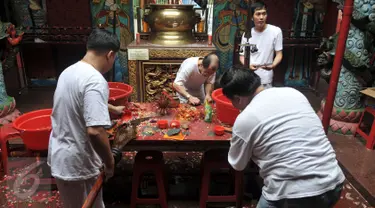 Umat Tionghoa mencuci dan membersihkan sejumlah alat pusaka seperti Pedang dan Golok saat prosesi pensucian tandu (kio) yang digunakan  mengusung arca suci saat perayaan cap go meh, di Vihara Bodhi Dharma, Jakarta, (20/2). (Liputan6.com/Johan Tallo)