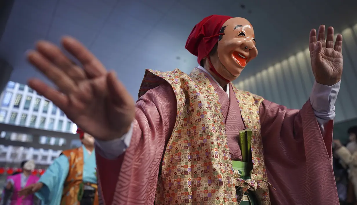 Seniman yang mengenakan topeng badut tradisional Jepang berbaris selama Festival Konpira di kuil Kotohiragu di distrik bisnis Toranomon, Tokyo, Selasa (10/1/2023). Festival Konpira pertama di tahun 2023 ini dimeriahkan dengan penampilan para seniman yang mengenakan topeng tradisional Jepang. (AP Photo/Eugene Hoshiko)