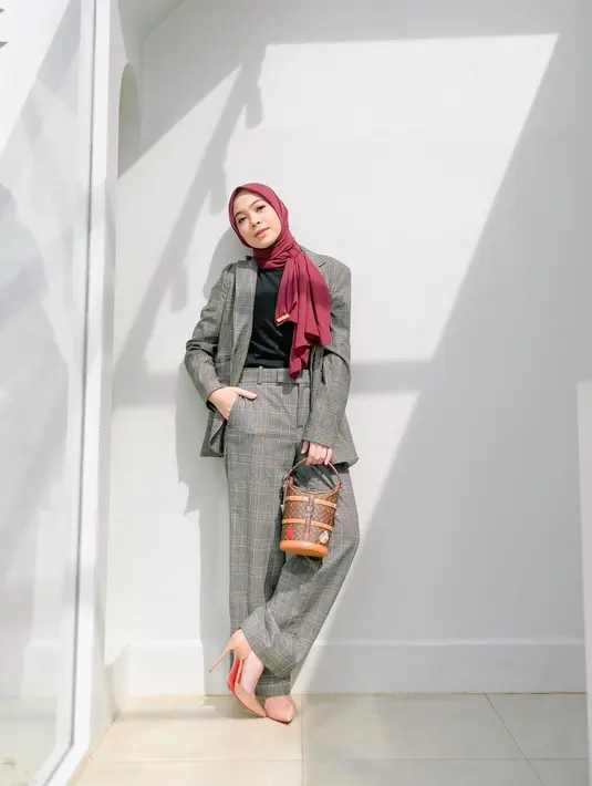 Dian Ayu tampil semi boyish kenakan set blazer tartan abu-abu. Dipadukan dengan inner hijan, hijab merah, dan heels [@dianayulestari]