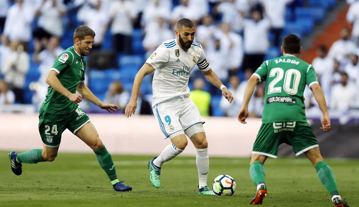 Striker Real Madrid, Karim Benzema, berusaha melewati pemain Leganes pada laga La Liga di Santiago Bernabeu, Sabtu (28/4/2018). Real Madrid menang 2-1 atas Leganes. (AP/Francisco Seco)