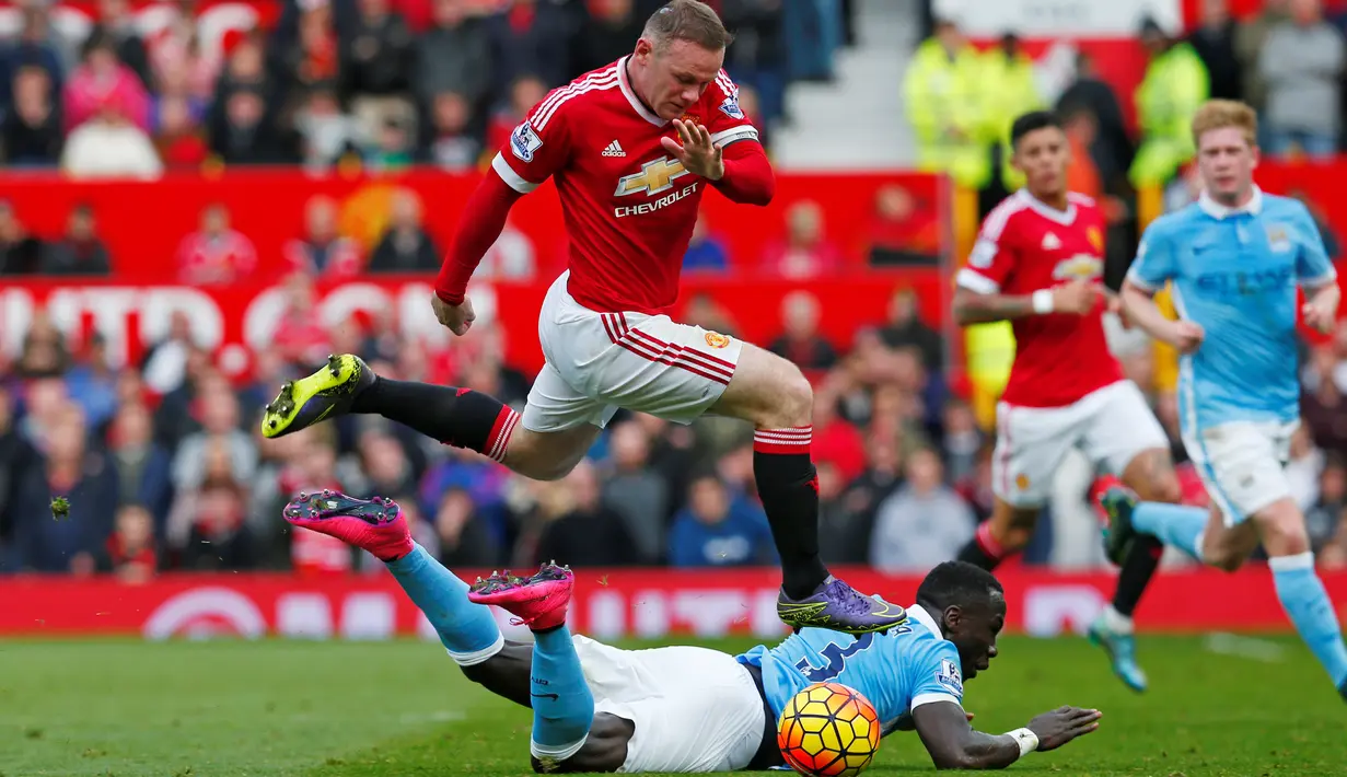 Pemain Manchester City, Bacary Sagna (bawah), berebut bola dengan pemain Manchester United, Wayne Rooney, dalam lanjutan Liga Premier Inggris di Stadion Old Trafford, Inggris, Minggu (25/10/2015). (Reuters/Eddie Keogh)