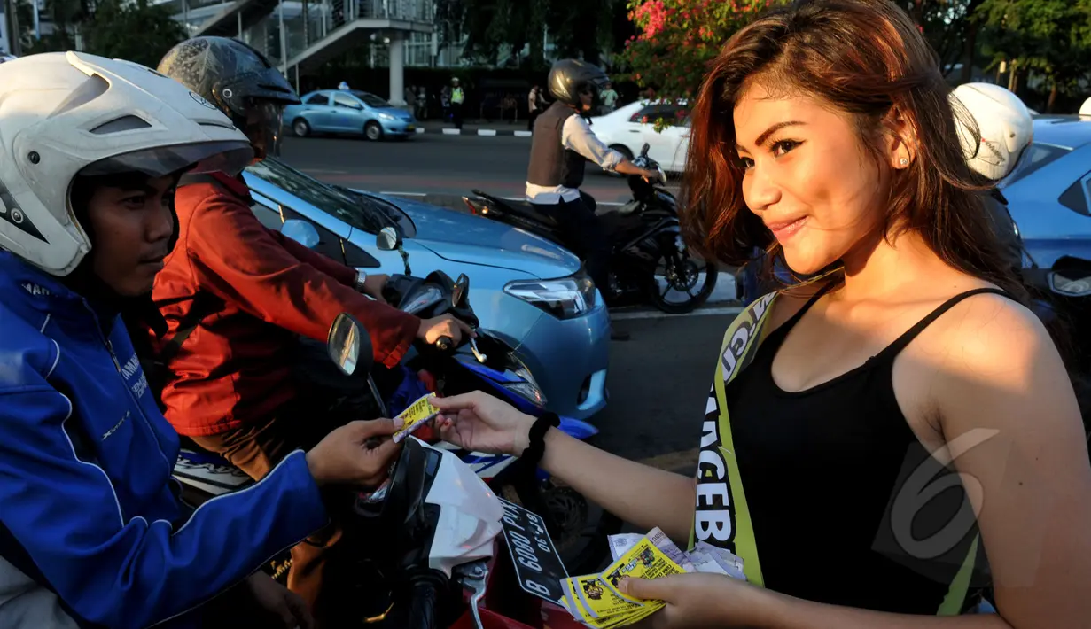 Sejumlah wanita cantik membagi-bagikan uang kepada warga yang melintas di Bundaran HI, Jakarta, Kamis (9/4/2015).  Kegiatan tersebut dalam rangka sosialisasi peluncuran sebuah aplikasi game online (Liputan6.com/Johan Tallo).