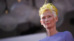 Tilda Swinton berpose untuk fotografer saat tiba untuk pemutaran film "The Eternal Daughter" selama Venice Film Festival 2022 ke-79 di di Lido di Venesia, Italia (6/9/2022). Aktris berusia 61 tahun itu  mengambil alih karpet merah dalam gaun lavender yang mempesona. (AFP/Tiziana Fabi)