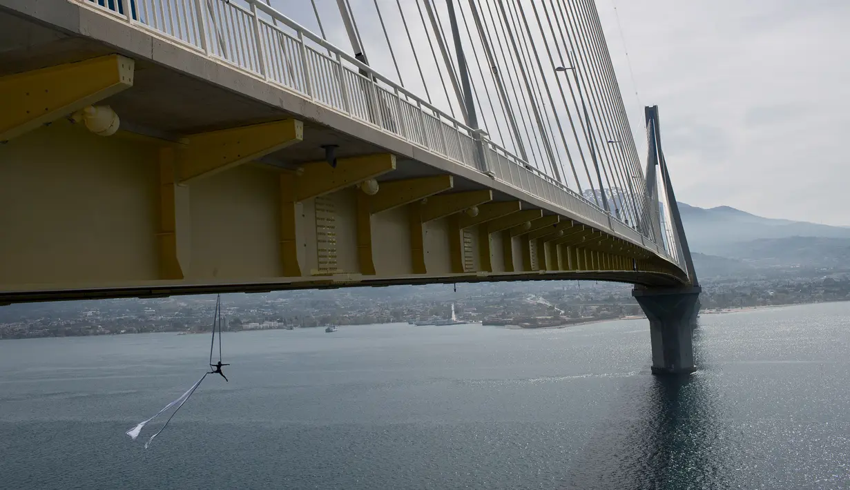 Seorang koreografer dan penari "ekstrem", Katerina Soldatou melakukan tarian di bawah jembatan Rio-Antirio, Yunani selatan, Senin (12/3).  Jembatan ini merupakan jembatan bentang kabel terpanjang di dunia. (AP Photo/Petros Giannakouris)