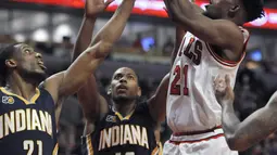 Pemain Chicago Bulls, Jimmy Butler (21) melakukan tembakan saat dihadang para pemain Indiana Pacers pada lanjutan NBA basketball game di United Center, (26/12/2016).  (AP /Paul Beaty)