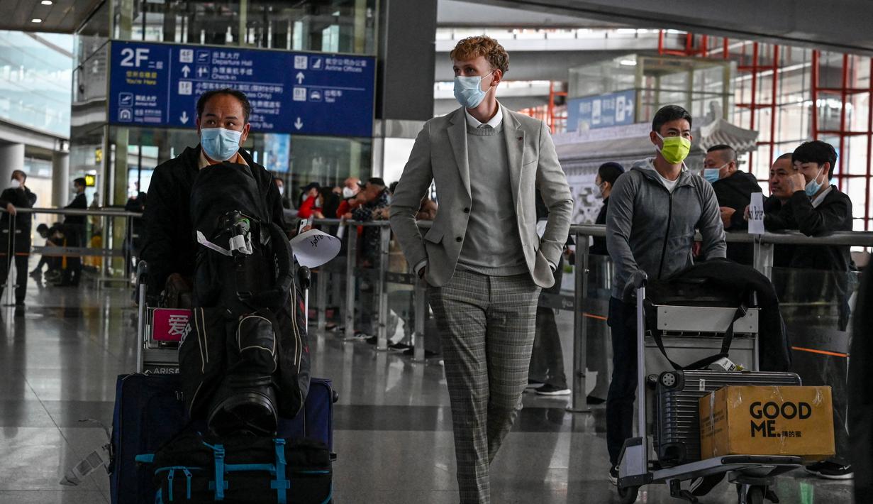 Penumpang berjalan melalui aula kedatangan untuk penerbangan internasional di Bandara Internasional Ibukota di Beijing, China, Selasa (14/3/2023). China akan kembali mengeluarkan berbagai visa untuk orang asing mulai 15 Maret besok, dalam pelonggaran besar-besaran pembatasan perjalanan sejak merebaknya pandemi Covid-19. (Photo by Jade GAO / AFP)