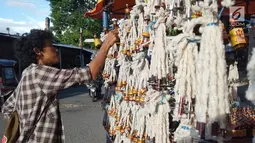 Pedagang merapikan pelita dagangannya yang dijual di Jalan Sam Ratulangi, Kota Gorontalo, Rabu (22/5/2019). Pelita ini terbuat dari botol bekas yang dipasangi sumbu. (Liputan6.com/Arfandi Ibrahim)