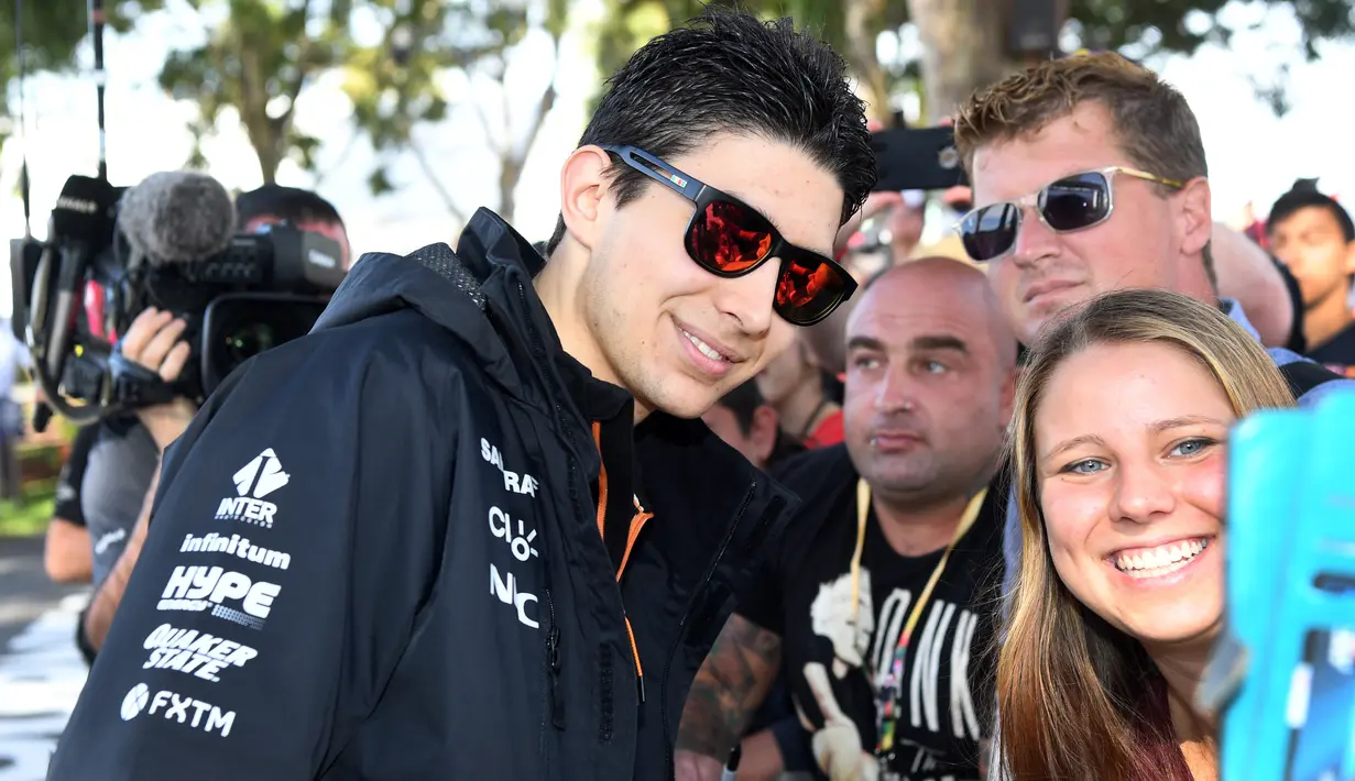 Seorang penggemar melakukan selfie dengan pembalap tim Force India, Esteban Ocon, menjelang sesi latihan bebas pertama di Grand Prix Australia, Melbourne, Jumat (24/3). (AFP Photo/WILLIAM WEST)