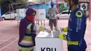 Petugas membantu pemilih memasukkan surat suara usai mencoblos dalam Pilkada 2020 di TPS 23 Pondok Jagung Timur, Tangerang Selatan, Rabu (9/12/2020). TPS Pilkada Tangerang Selatan (Tangsel) itu menggunakan tema hobi dimana petugasnya mengenakan pakaian untuk bersepeda. (Liputan6.com/Angga Yuniar)
