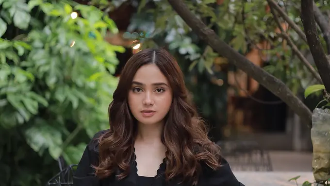 Syifa Hadju duduk di sebuah bangku taman dengan menampilkan Tabby Shoulder Bag 20 Coach (Foto Dok: KANMO GROUP)