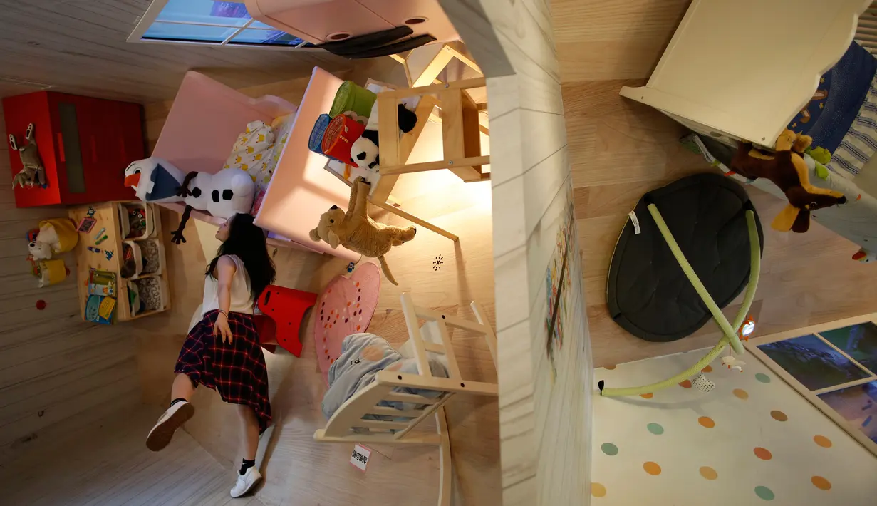 Pengunjung wanita bermain dikamar rumah terbalik di Huashan Creative Park, Taipei, Taiwan, (7/4). Sekelompok arsitek Taiwan membangun rumah seluas 300 meter yang menghabiskan dana US$ 600.000 dalam kurun waktu 2 bulan. (REUTERS/Tyrone Siu)