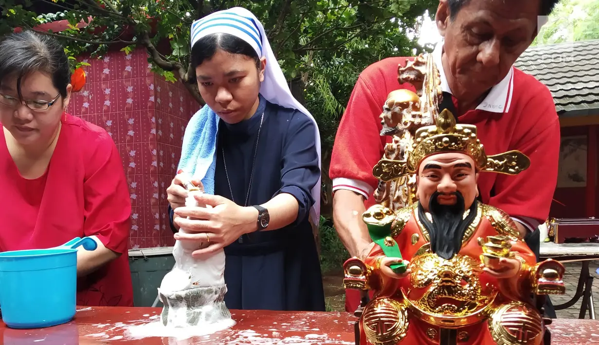 Suster Katolik bersama pengurus vihara membersihkan patung dewa dewi di Vihara Kwan In Thang, Pondok Cabe, Tangerang Selatan, Rabu (30/1). Pembersihan patung dewa dewi itu merupakan salah satu tradisi menyambut Tahun Baru Imlek. (Merdeka.com/Arie Basuki)