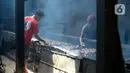 Pekerja menyusun ikan lele yang diasapin (panggang) di Kelurahan Pengasinan, Bogor, Jawa Barat, Jumat (11/09/2020). Permintaan ikan lele asap meningkat dalam satu hari bisa memproduksi 4 sampai 5 kuintal yang akan di kirim ke Jabodetabek hingga di ekspor ke Nigeria. (merdeka.com/Dwi Narwoko)