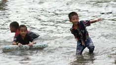 Sejumlah anak-anak bermain di genangan air akibat banjir rob di kawasan pintu masuk Pelabuhan Nizam Zachman, Muara Baru, Jakarta, Jumat (5/6/2020). Banjir rob di Pelabuhan Muara Baru tersebut terjadi akibat cuaca ekstrem serta pasang air laut. (Liputan6.com/Helmi Fithriansyah)