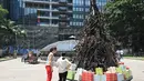 Dua wanita melihat instalasi yang dijuluki 'Pohon Natal yang Terbakar' di Sydney (18/12/2019). Warga Australia di pantai timur bersiap menghadapi "ancaman baru" ketika gelombang panas disertai dengan angin yang bergolak menurunkan lebih dari 100 kebakaran hutan di kawasan itu. (AFP/Peter Parks)