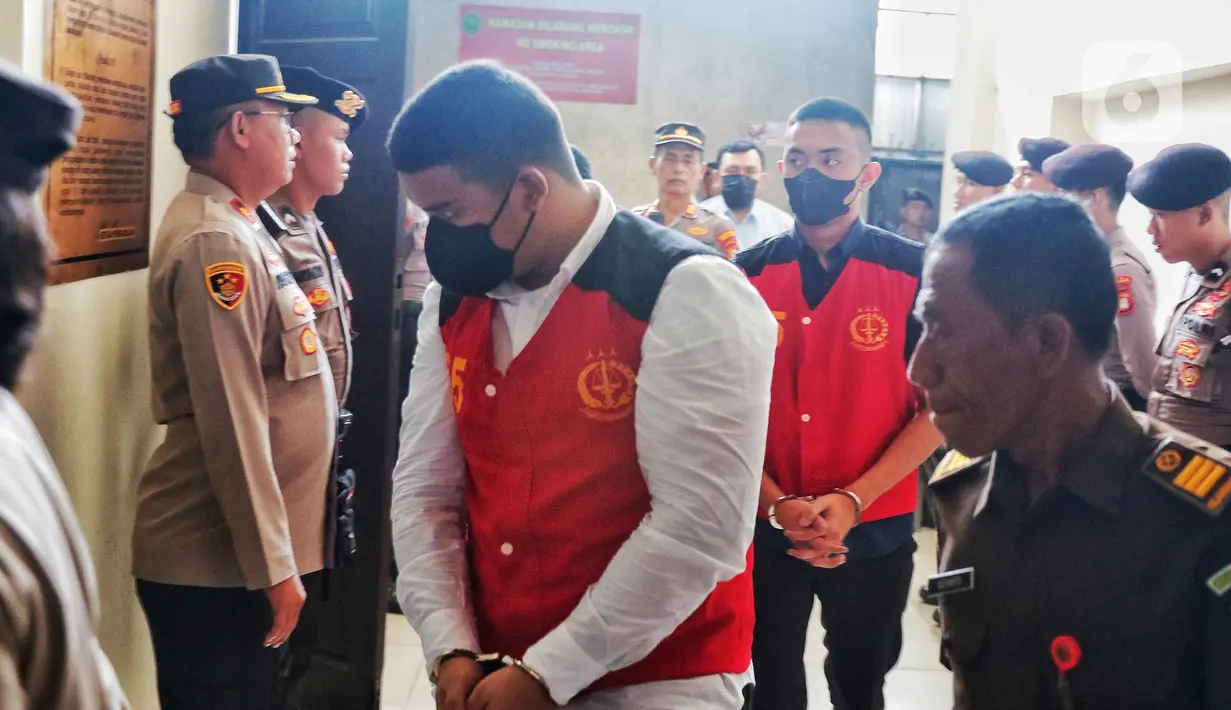 Mario Dandy Satriyo tampak mengenakan atasan dan bawahan hitam, sementara Shane Lukas mengenakan atasan putih dan bawahan hitam. Keduanaya mengenakan masker hitam dan tangan terborgol saat berjalan menuju ruang sidang. (Liputan6.com/Angga Yuniar)