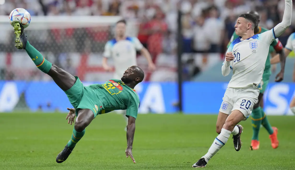 Bek Senegal Youssouf Sabaly menantang gelandang Inggris Phil Foden pada laga babak 16 besar Piala Dunia 2022 di Al Bayt Stadium, Senin (5/12/2022) dini hari WIB.  Inggris lebih mendominasi penguasaan bola, tetapi masih belum banyak ancaman berbahaya yang diperlihatkan tim asuhan Gareth Southgate. (AP Photo/Hassan Ammar)