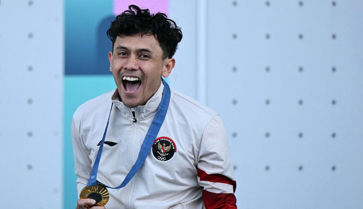<p>Ekspresi bahagia atlet panjat tebing Indonesia, Veddriq Leonardo saat berhasil meraih medali emas cabang olahraga panjat tebing nomor speed Olimpiade Paris 2024 di Le Bourget Sport Climbing Venue, Paris, Prancis, Kamis (08/08/2024). (AFP/Jonathan Nackstrand)</p>
