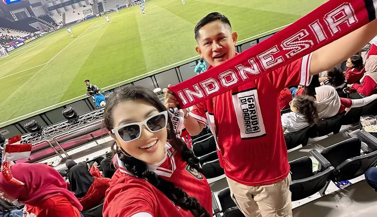 Dalam unggahannya, Fitri mengaku begitu bangga melihat secara langsung perjuangan Garuda Muda di ajang AFC 2024. Sama seperti suporter Indonesia lainnya, ia dan sang suami juga kompak memakai kaos jersey Timnas Indonesia. (Liputan6.com/IG/@fitricarlina)