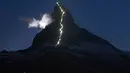Deretan cahaya memanjang, terlihat di punggung gunung Matterhorn, Zermatt, Swiss, Senin (13/7/2015). Lampu tersebut dipasang merayakan keberhasilan Briton Edward Whymper, menaklukan puncak gunung Matterhorn pada 14 Juli 1865. (REUTERS/Denis Balibouse)