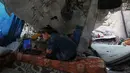 Banyak dari mereka terpaksa tinggal di tenda-tenda darurat, sekolah yang penuh sesak, atau tidur di tempat terbuka di tengah reruntuhan bangunan. Tampak dalam foto, Bisan Taroush menonton film di laptop di bawah atap rumahnya yang sebagian runtuh, menjalani kehidupan sehari-hari di tengah reruntuhan, di Jabaliya, Kota Gaza, Selasa, 11 November 2025. (AP Photo/Jehad Alshrafi)