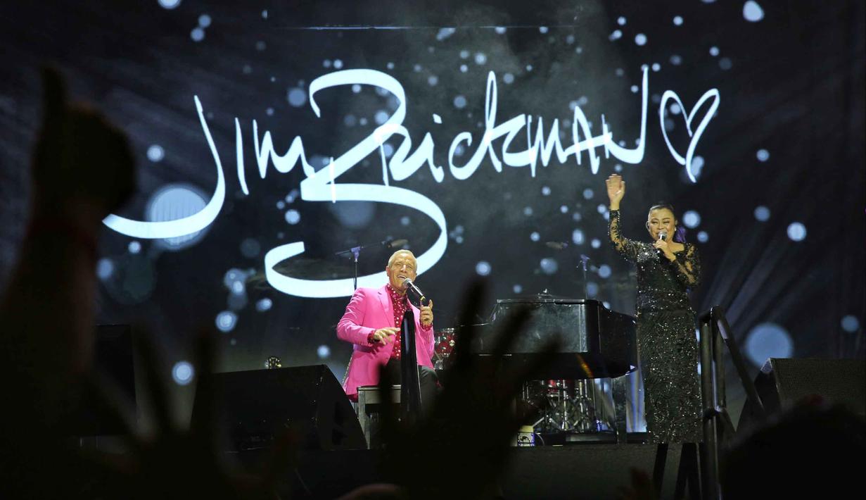 Mereka menyatu mengajak penonton mengenang kembali masa keemasan musik pop dan pop rock dalam Konser 90's Intimate 2nd Edition. Tampak dalam foto, penampilan asal Amerika Serikat, Jim Brickman saat berduet dengan Rita Effendy (Indonesia) di konser 90's Intimate 2nd Editionkonser  di Istora Senayan, Jakarta, Sabtu (7/2/2026). (Fimela.com/Adrian Putra)