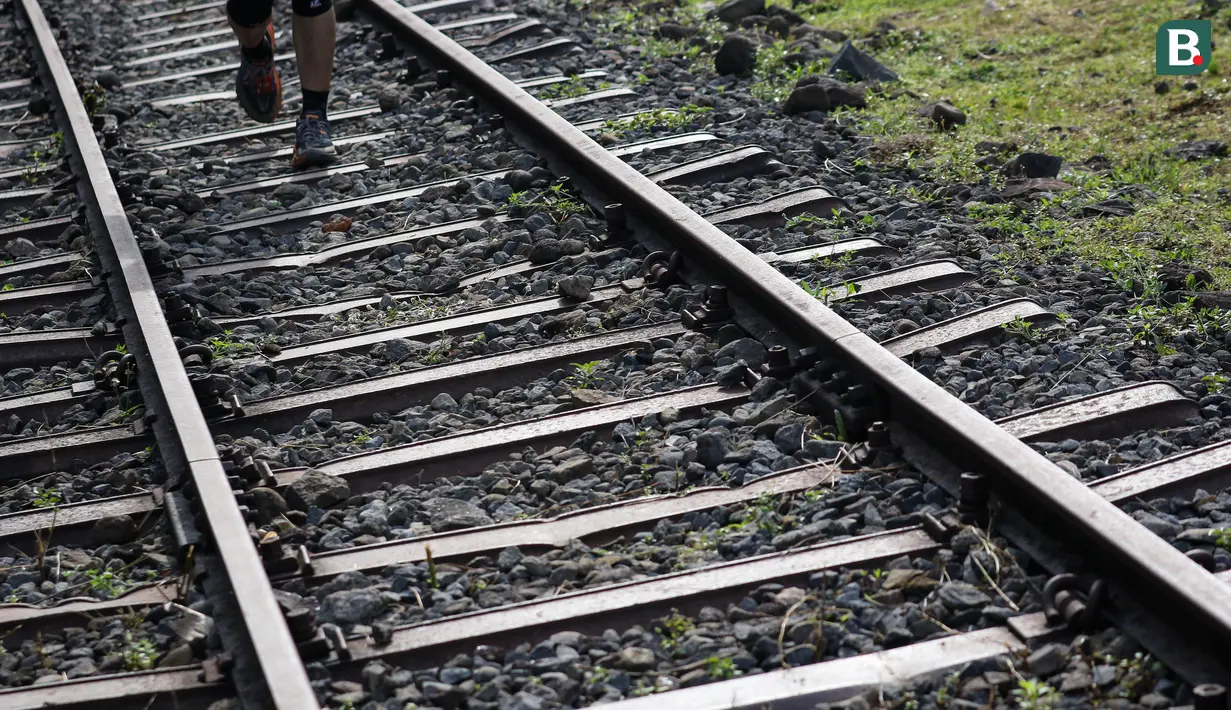 Jalur rel kereta api mulai menghilang mulai enam kilometer terakhir. Beberapa telah tertutup beton dan beralih fungsi menjadi jalanan. Peserta kemudian harus berlanjut melintasi jalur tanah. (Bola.com/Bagaskara Lazuardi)