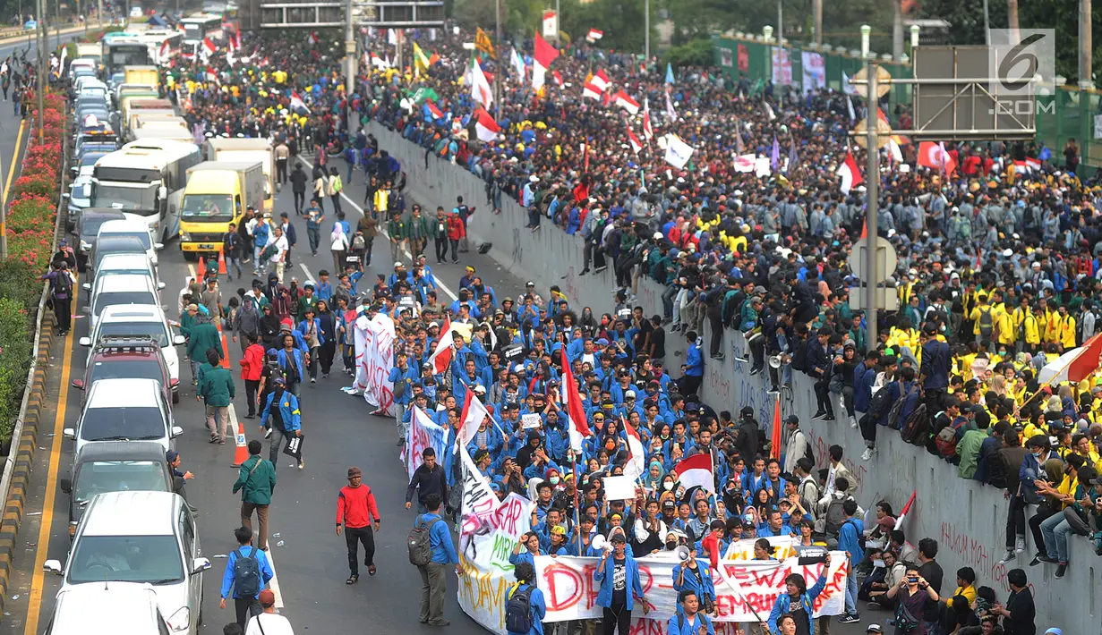 Mahasiswa memblokade Tol Dalam Kota saat berdemonstrasi menolak RUU KUHP dan revisi UU KPK di depan Gedung DPR, Jakarta, Selasa (24/9/2019). Sekitar pukul 15.00 WIB, mahasiswa yang berada di ruas Jalan Gatot Subroto memanjat tembok pembatas kemudian memadati Tol Dalam Kota. (merdeka.com/Arie Basuki)